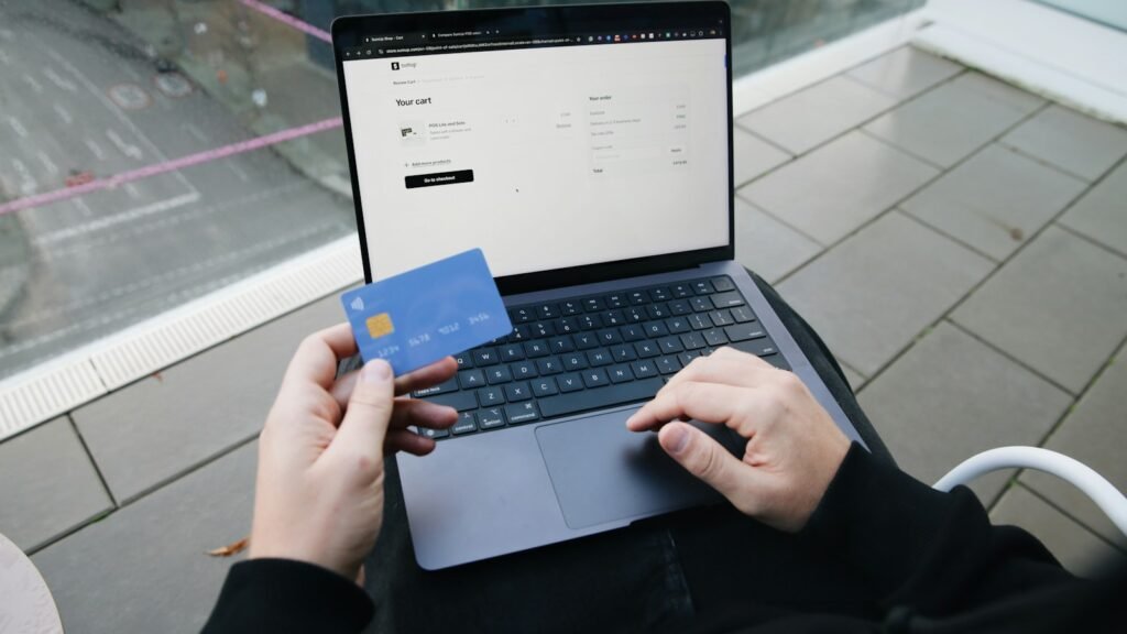 Personne avec un ordinateur portable et une carte bancaire
