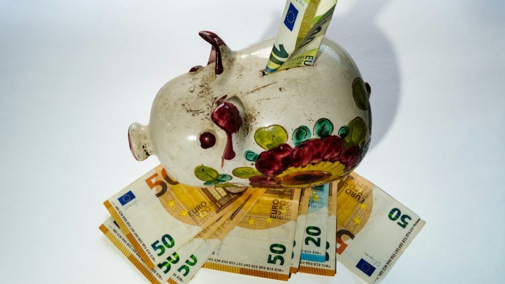 Tirelire posée sur des billets en euros