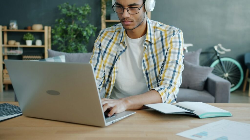 Étudiant avec un casque travaillant sur son ordinateur portable