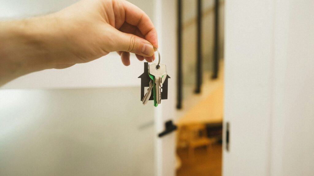 Main tenant une clé devant une porte
