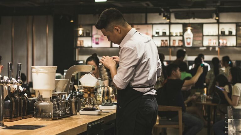 Jeune serveur préparant des boissons derrière un bar